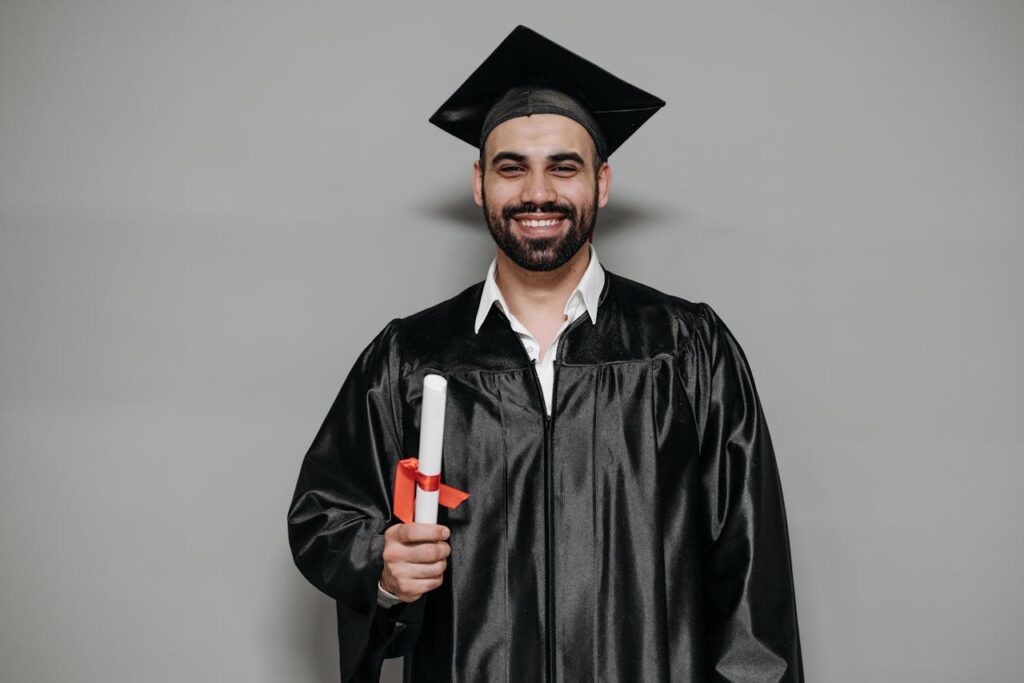 Happy bearded man in graduation attire, celebrating academic success.